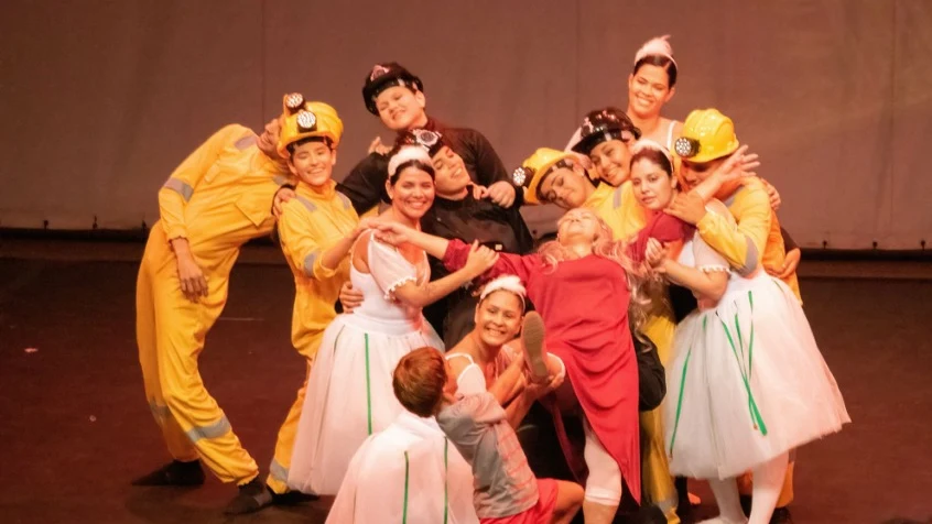 Grupo do elenco abraçado em cena do Billy Elliot