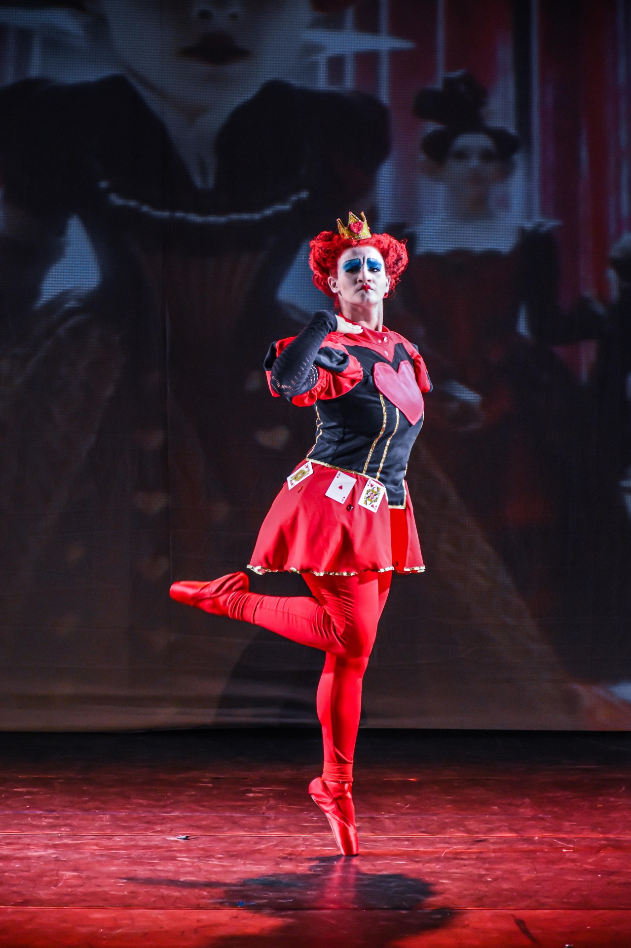 Rainha de Copas em pose solo no palco do espetáculo Alice