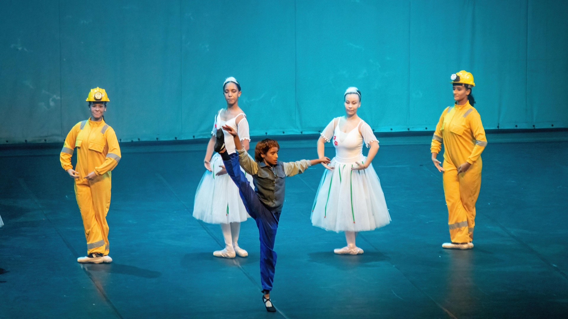 Billy em arabesque entre bailarinas e mineiras no espetáculo Billy Elliot